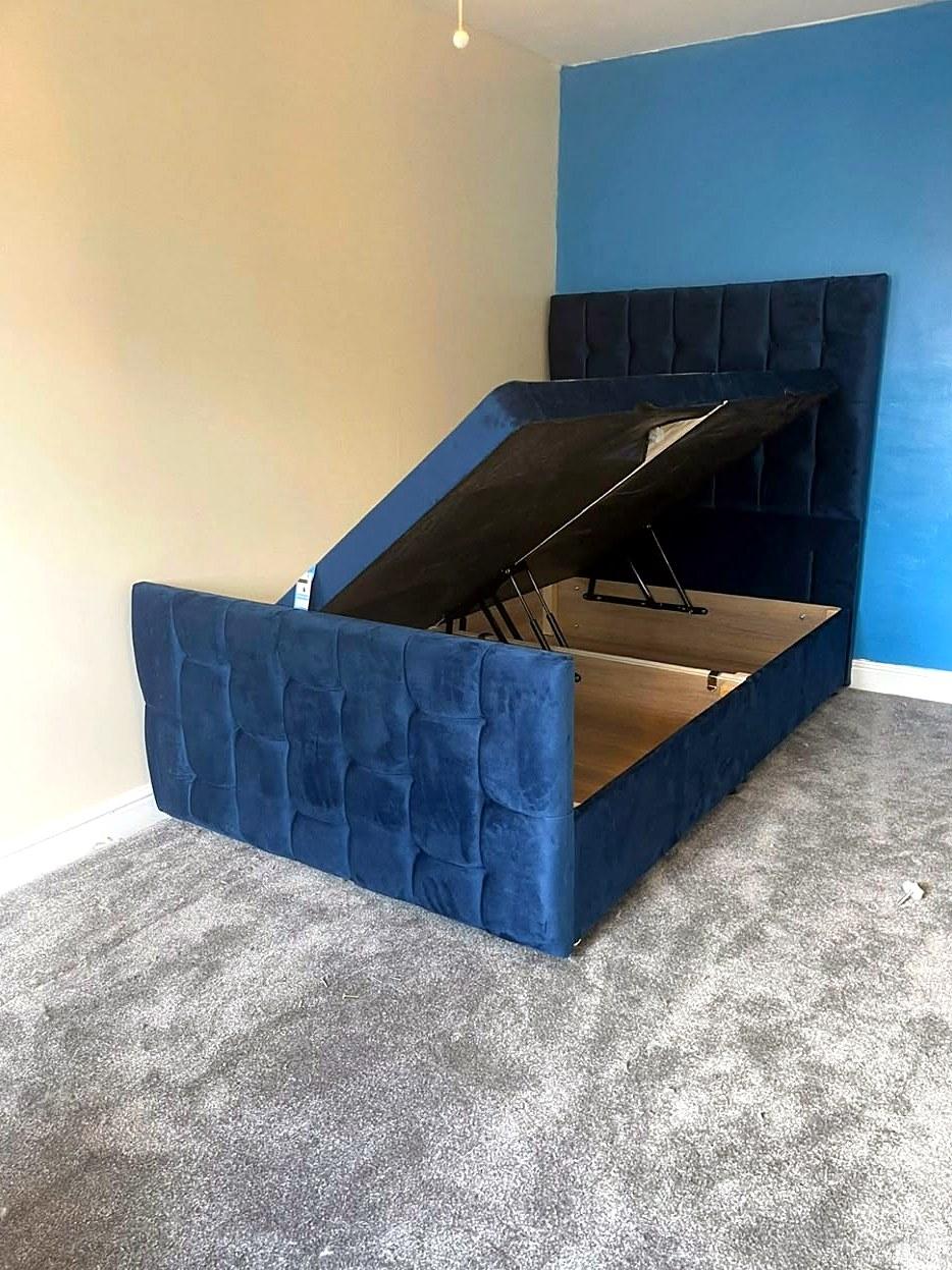 Blue velvet ottoman bed, assembled with the lift-up storage base open