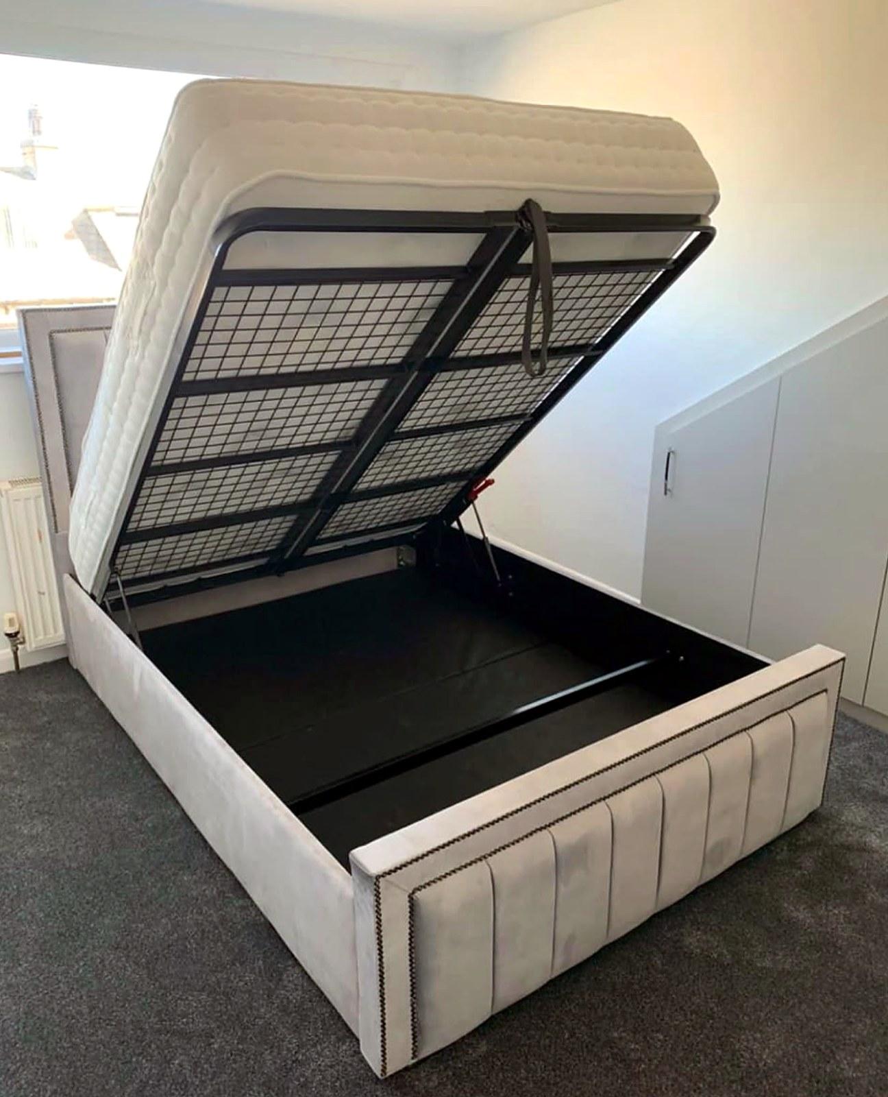 Grey upholstered ottoman bed, assembled with the storage base lifted open