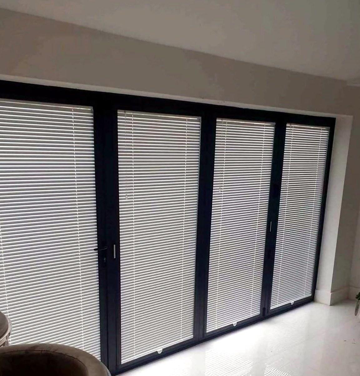 Perfect fit venetian blinds on all four panels of a dark-framed bifold door
