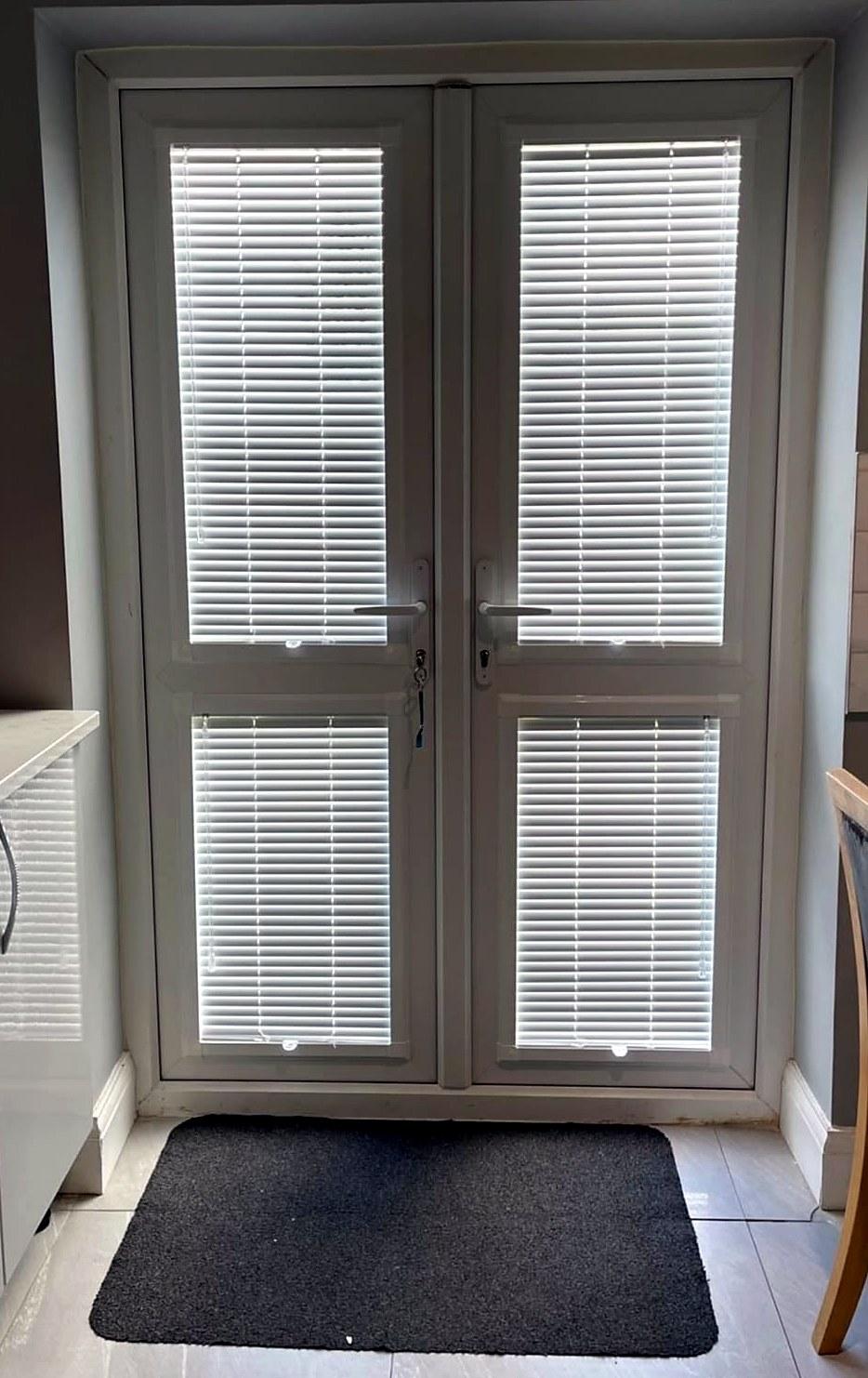 Perfect fit venetian blinds fitted to the glass panels of white French doors