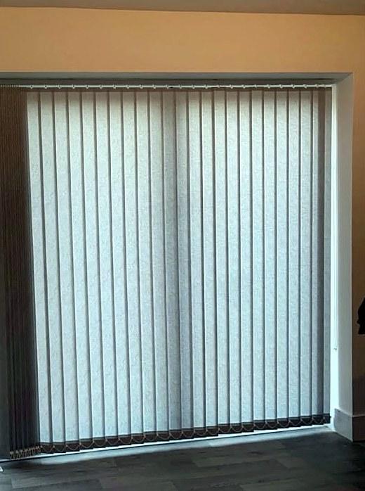 Pale vertical blind fitted across a patio door
