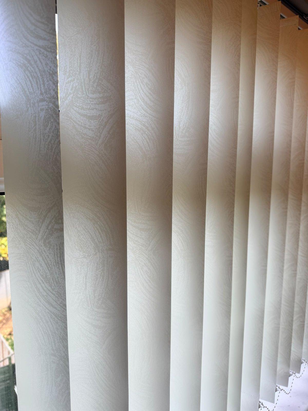 Close view of cream patterned vertical louvres