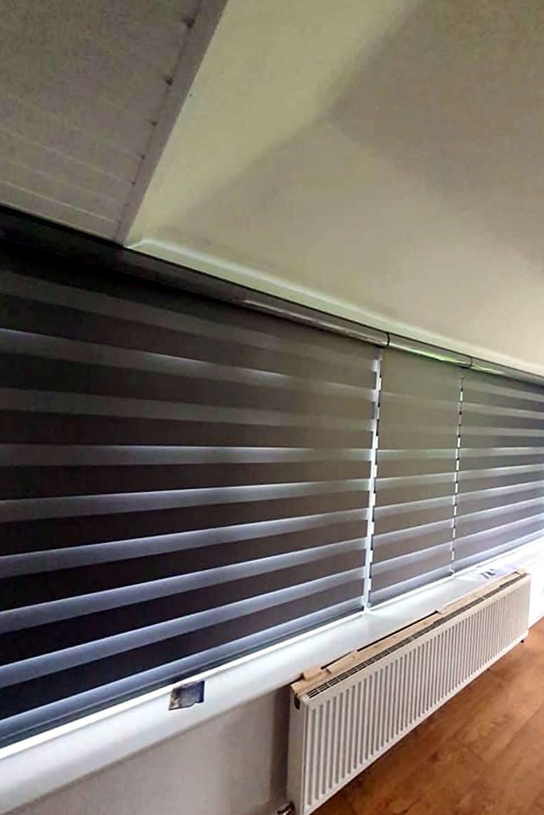 Dark day and night blinds fitted across a bay window above a radiator