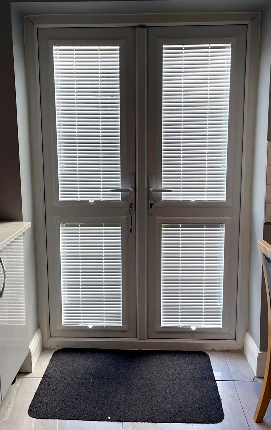 Perfect fit venetian blinds fitted to the glass panels of white French doors